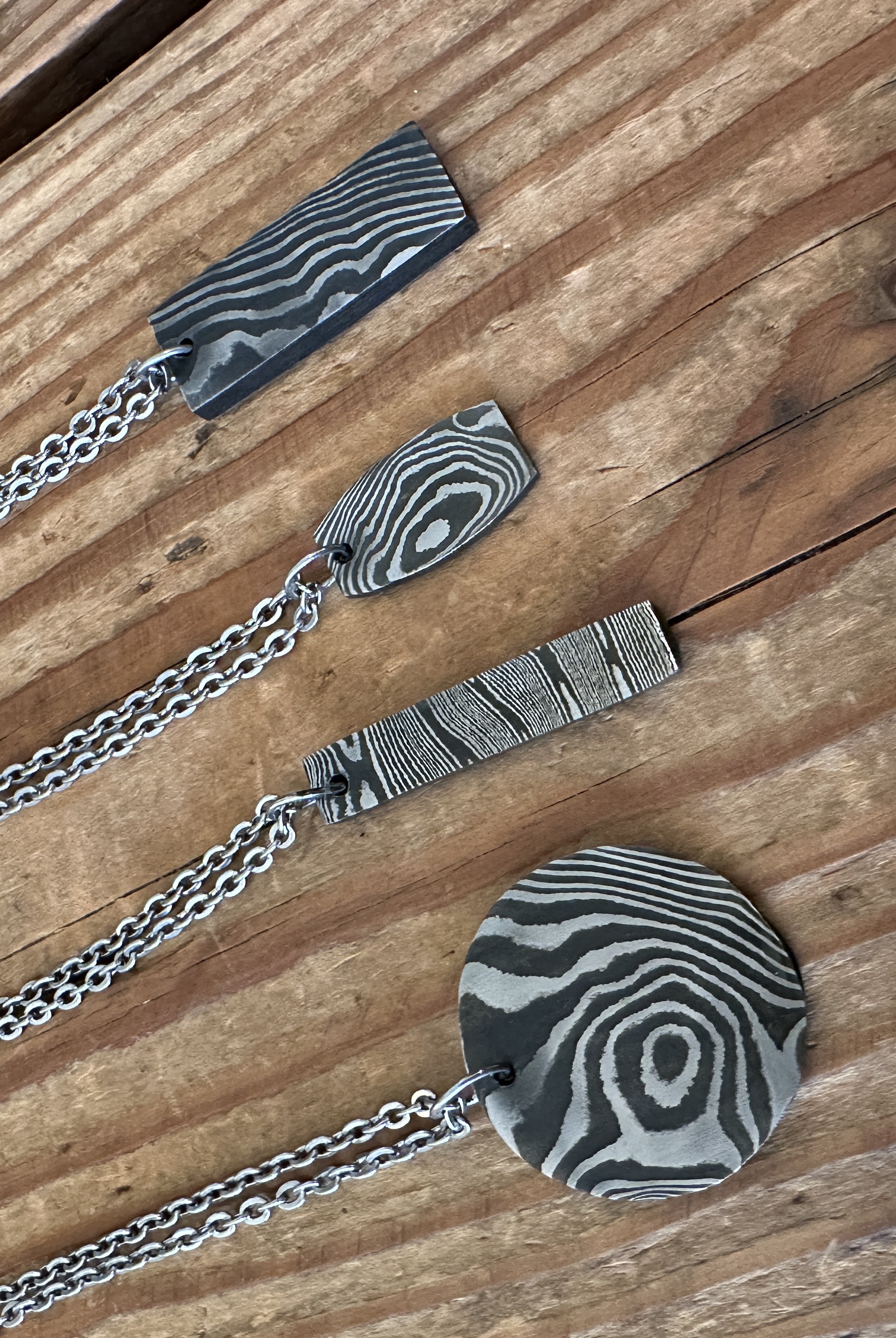 four damascus steel pendants